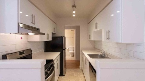 a kitchen with white cabinets and a sink and a stove