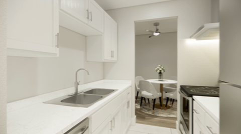 A kitchen with white cabinets and a black countertop.