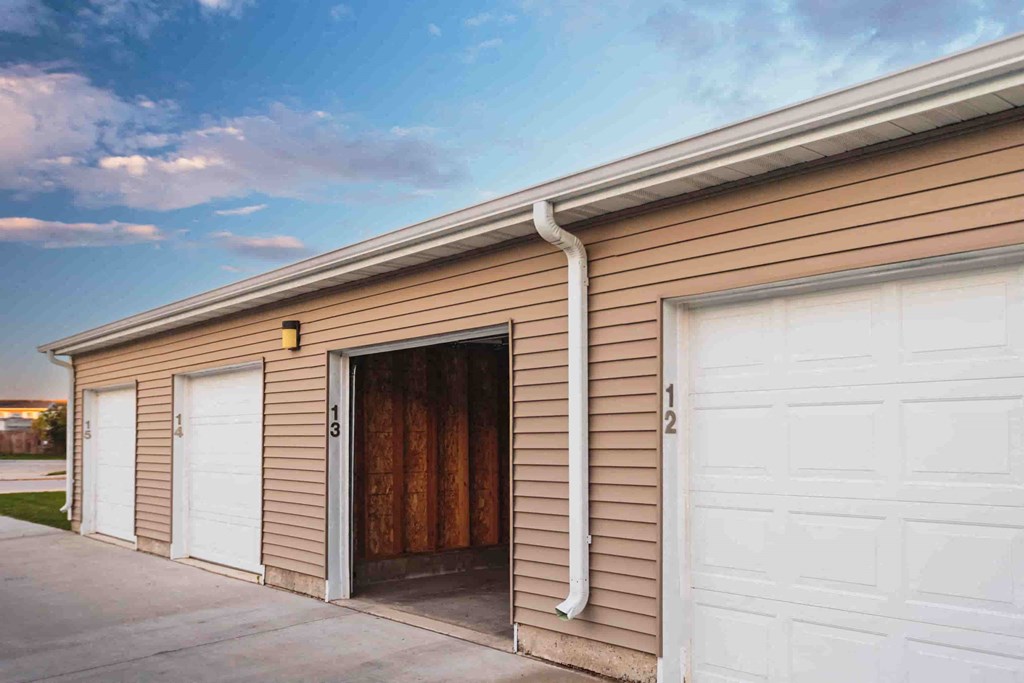 a garage with three white garage doors on a building