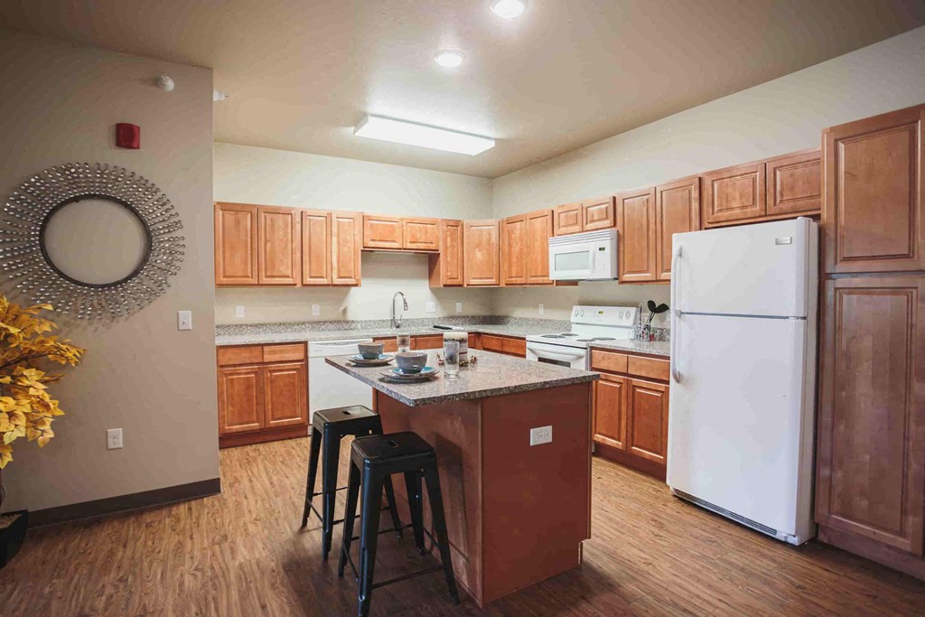 a kitchen with a center island and a white refrigerator