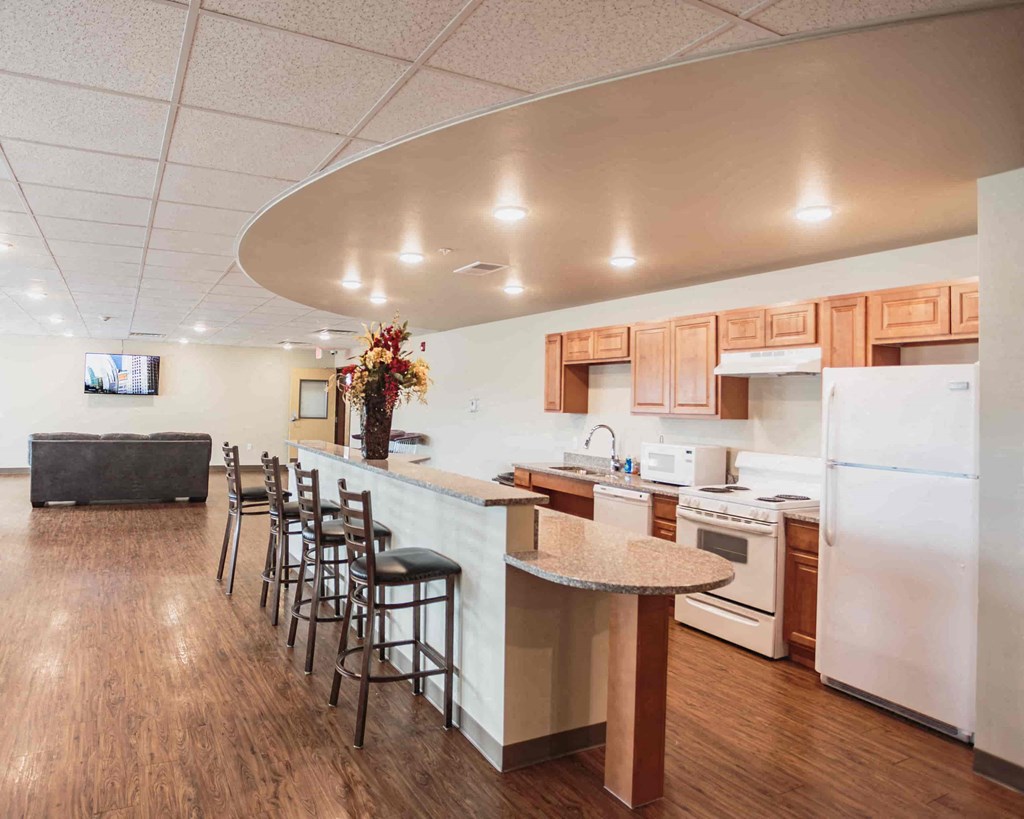 a kitchen with a bar and a counter top with chairs