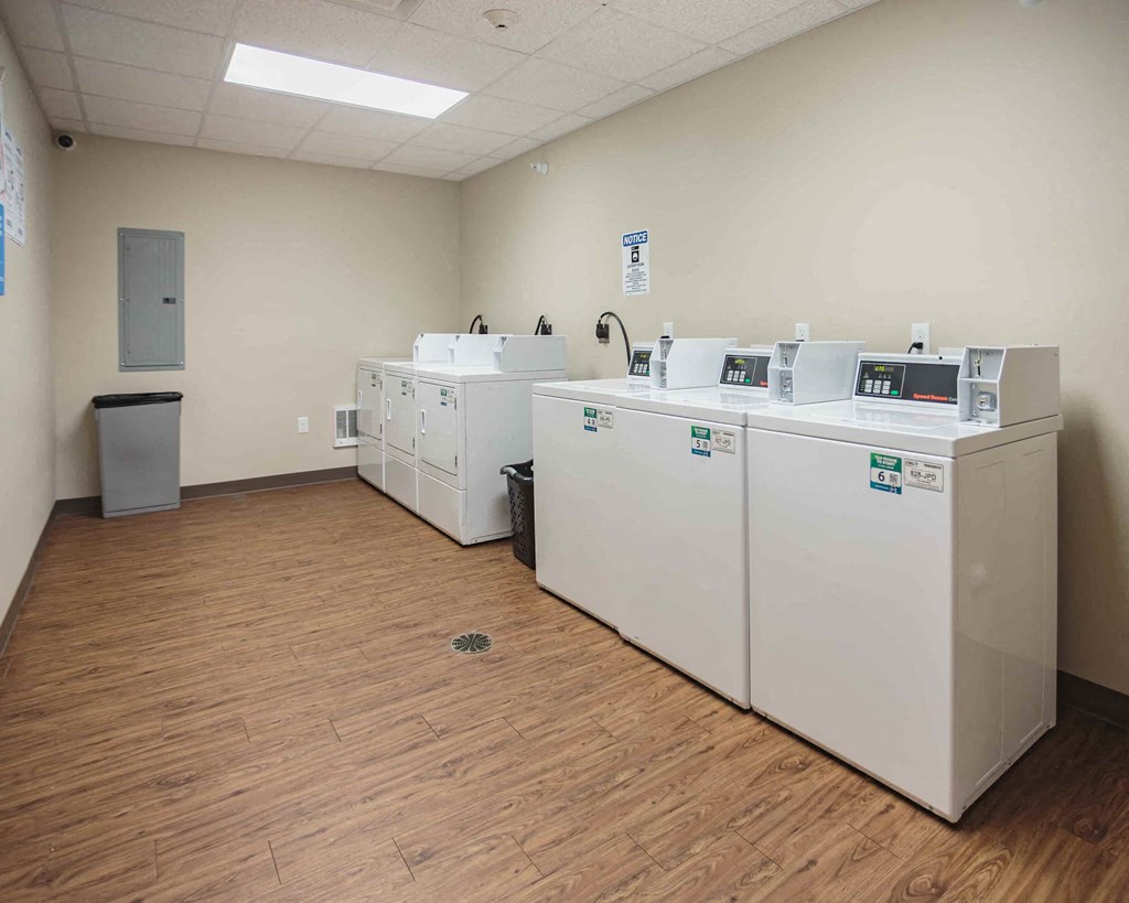 a room with four washes and dryers in it