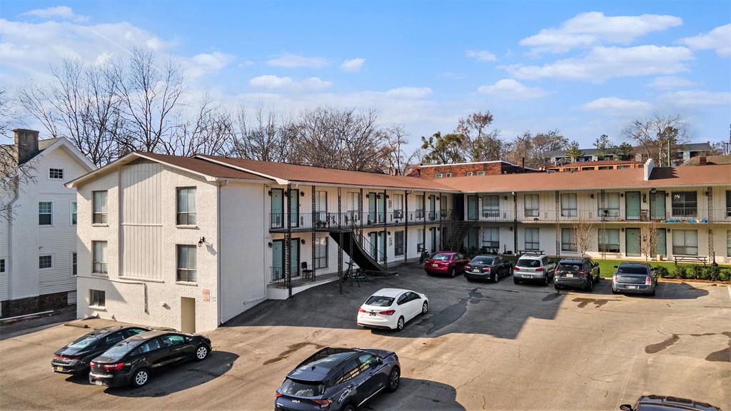 the building where the motel is located has a parking lot with cars