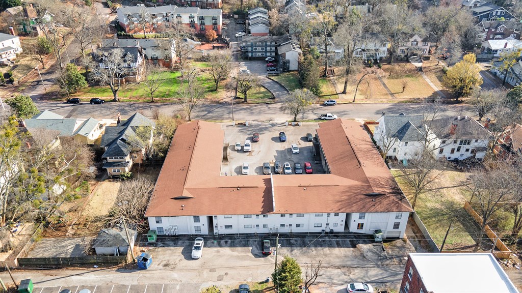 an aerial view of a building with a red roof and a parking lot