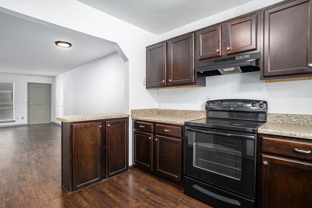 a kitchen with black appliances and wooden cabinets and granite counter tops