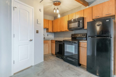 a kitchen with black appliances and wood cabinets