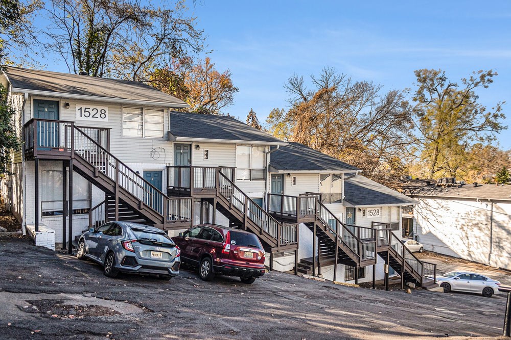 a row of houses with cars parked in front of them