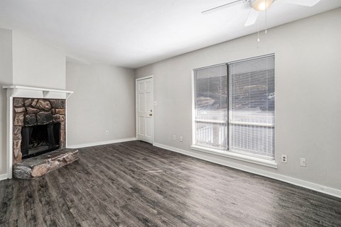 an empty living room with a fireplace and a window