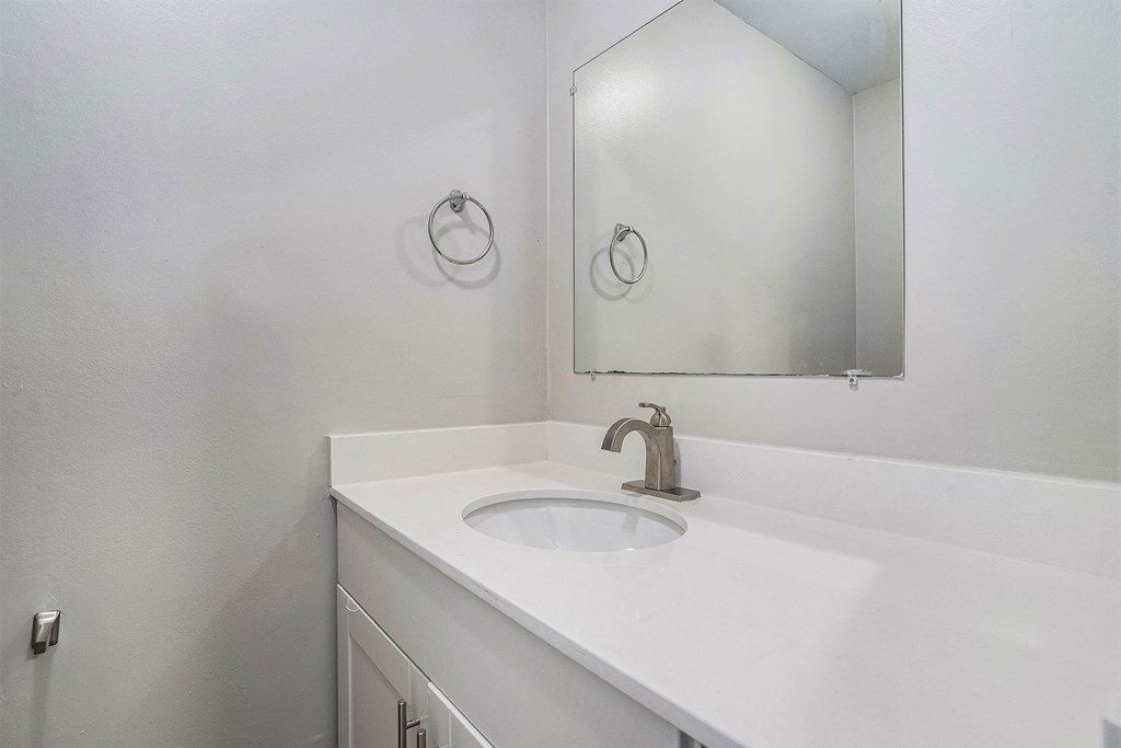 an empty bathroom with a sink and a mirror