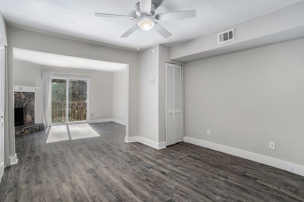 an empty living room with a ceiling fan