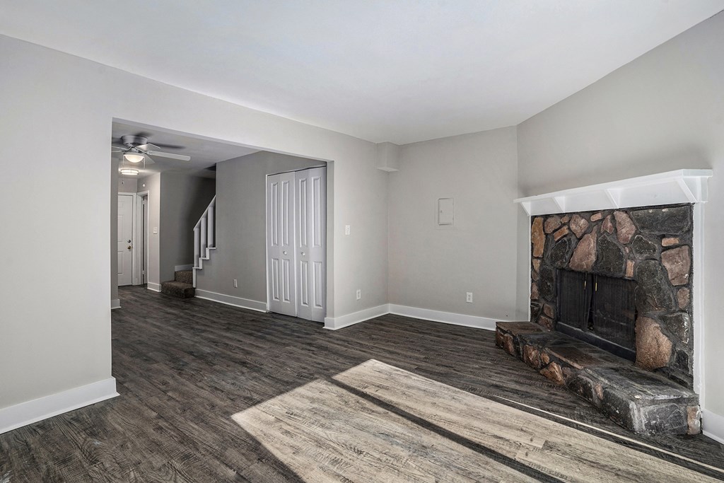 a living room with a fireplace and a door into a hallway