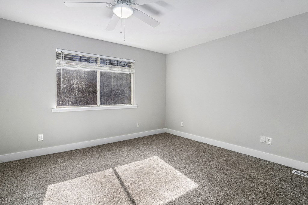 an empty room with carpet and a window