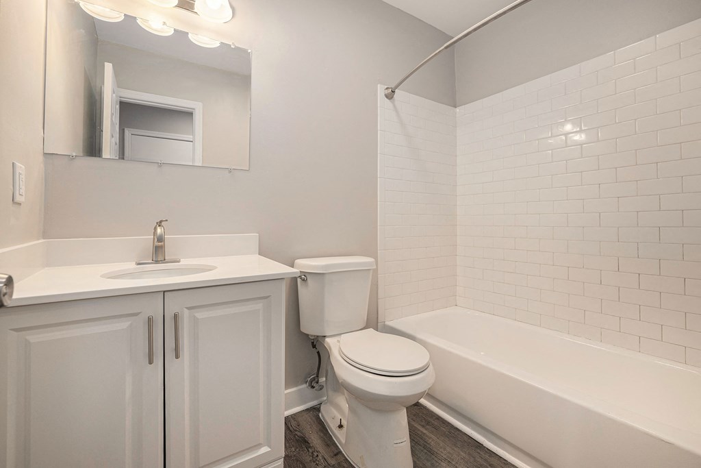 a bathroom with a toilet sink and tub and a mirror