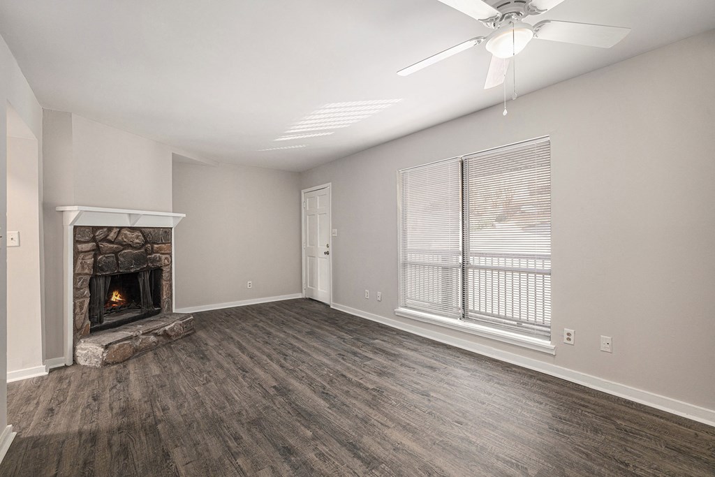 an empty living room with a fireplace and a window