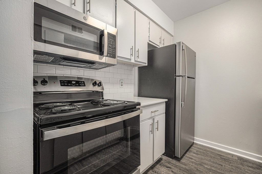 a kitchen with stainless steel appliances and white cabinets