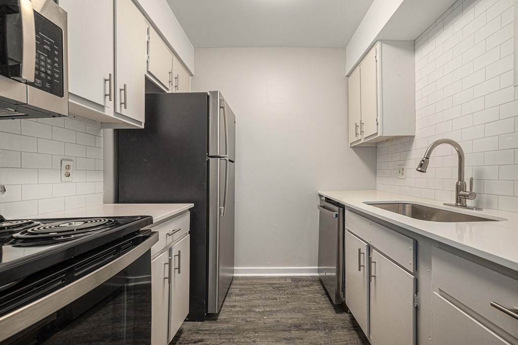 a kitchen with white cabinets and stainless steel appliances and a sink