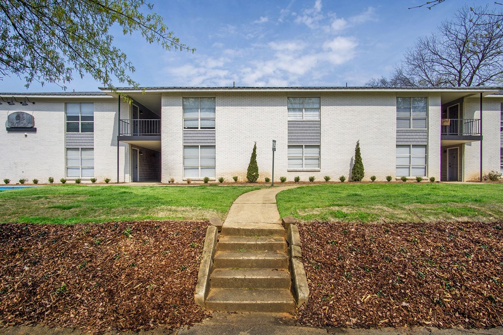 front view of an apartment building with stairs to the sidewalk