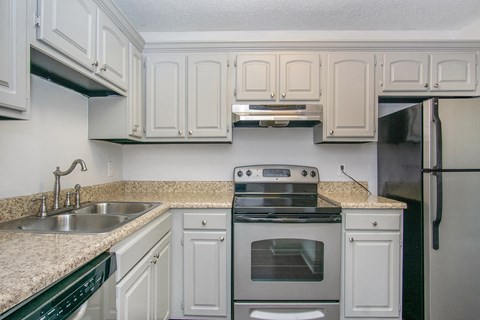 a kitchen with white cabinets and a sink and a stove