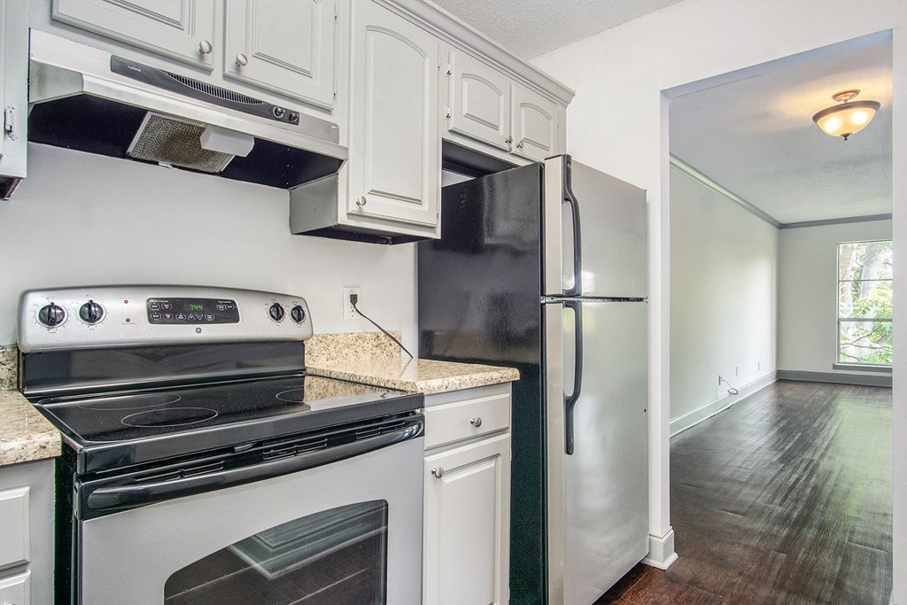 a kitchen with white cabinets and stainless steel appliances and a refrigerator