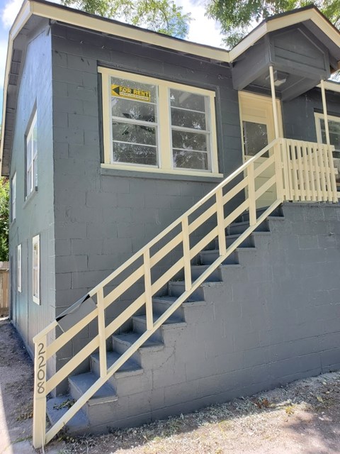 A house with a staircase leading to a balcony.