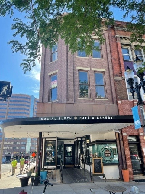 a brick building with a cafe and a bakery on the street