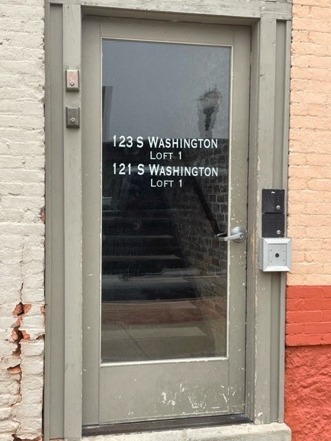 A door with a glass window and a sign on it.