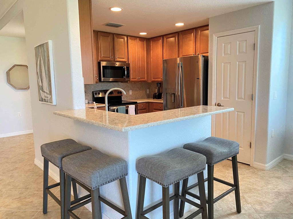 a kitchen with a counter and three bar stools