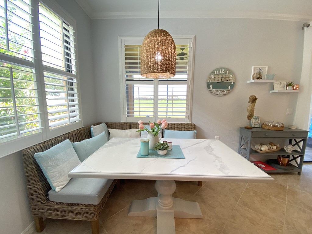 a dining room with a white table and chairs and a pendant light