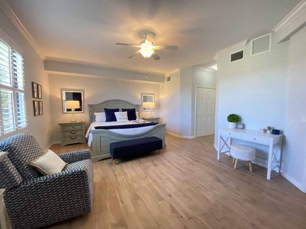 a bedroom with a large bed and a ceiling fan