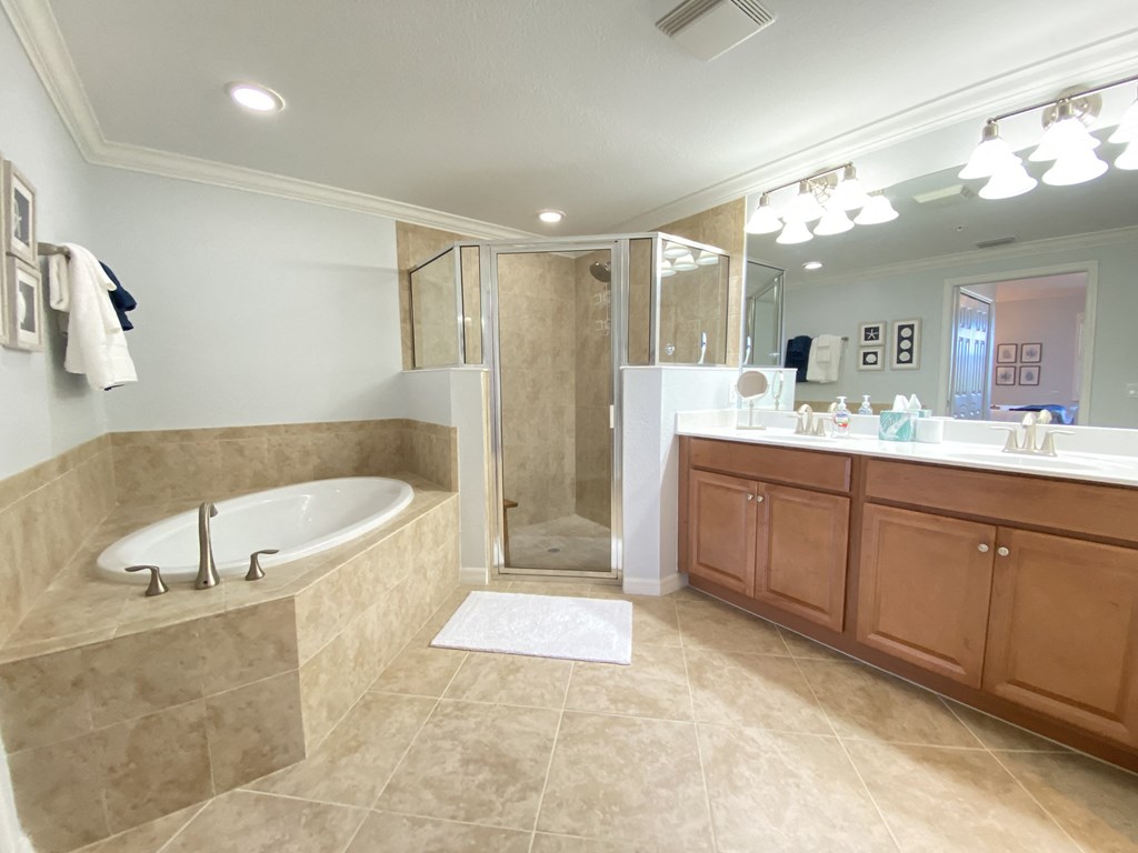 a large bathroom with a tub and a sink and a shower