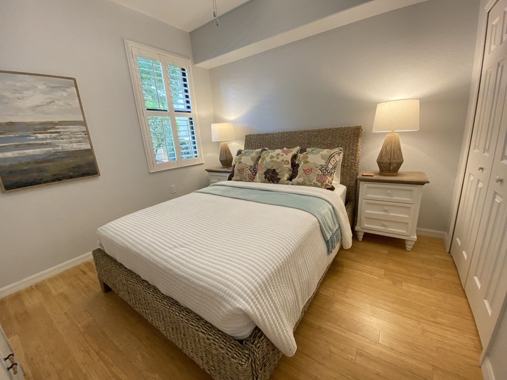 a bedroom with a bed and two night stands and a window