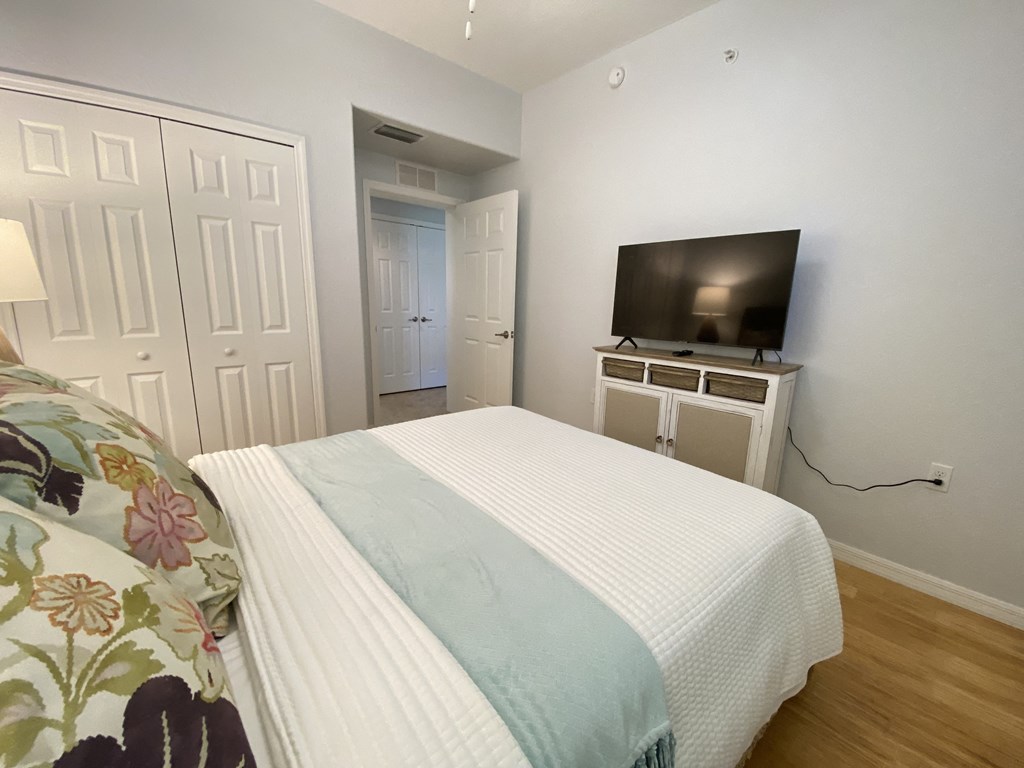 a bedroom with a bed and a tv on the wall