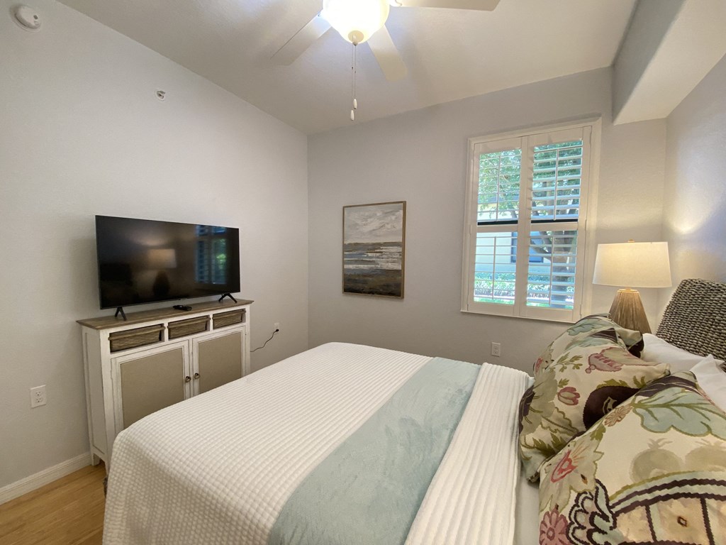 a bedroom with a bed and a tv on a dresser