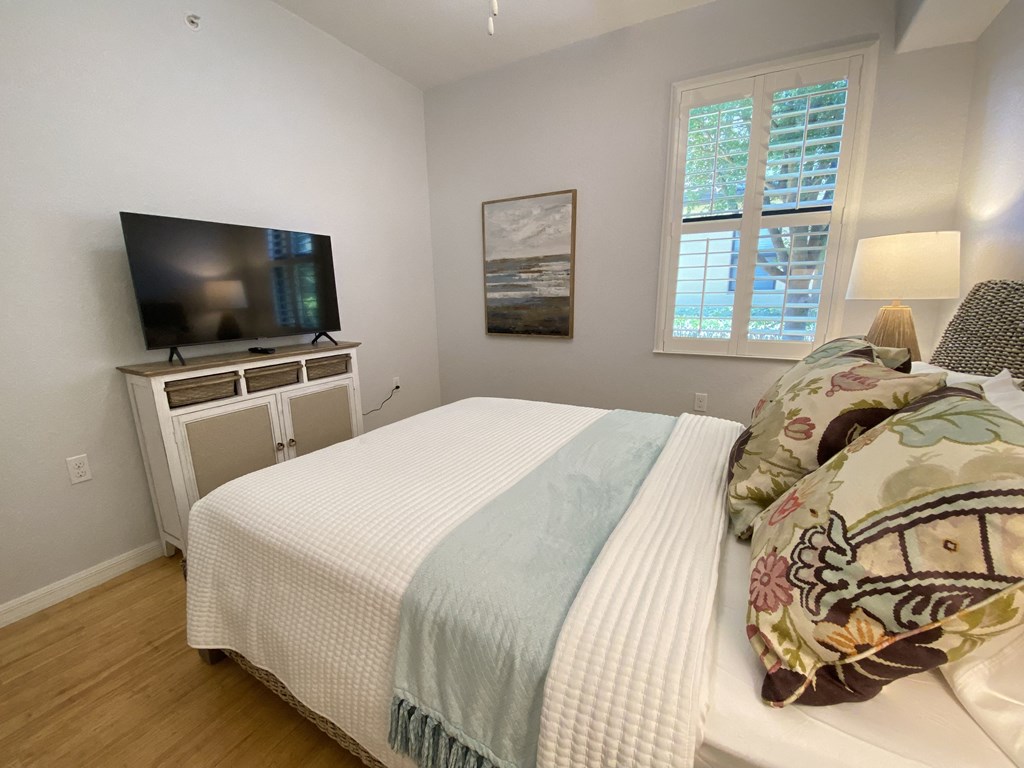 a bedroom with a bed and a tv in the corner