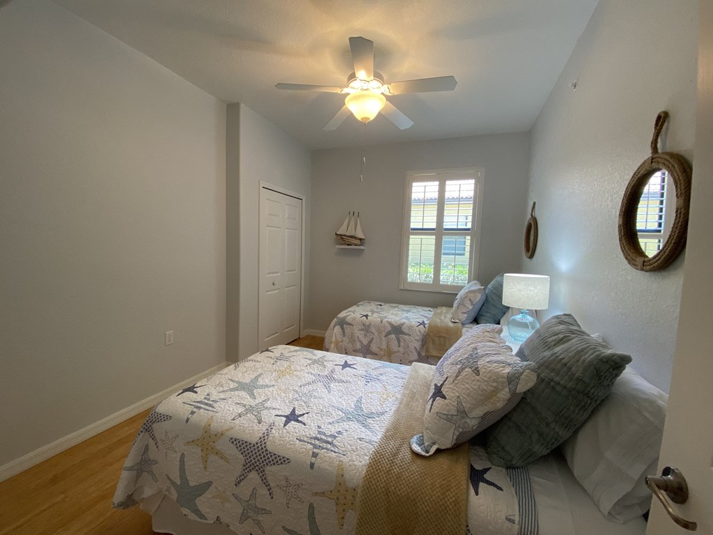 a bedroom with two beds and a ceiling fan