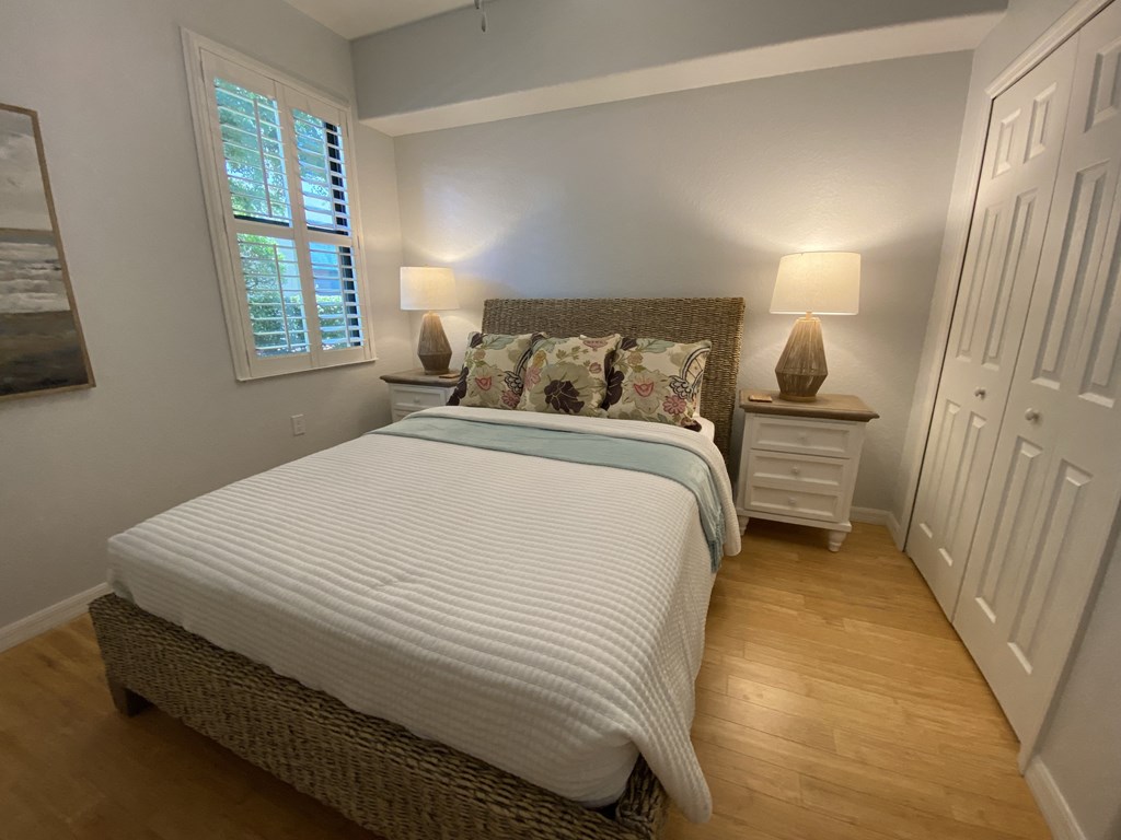 a bedroom with a bed and two lamps and a window