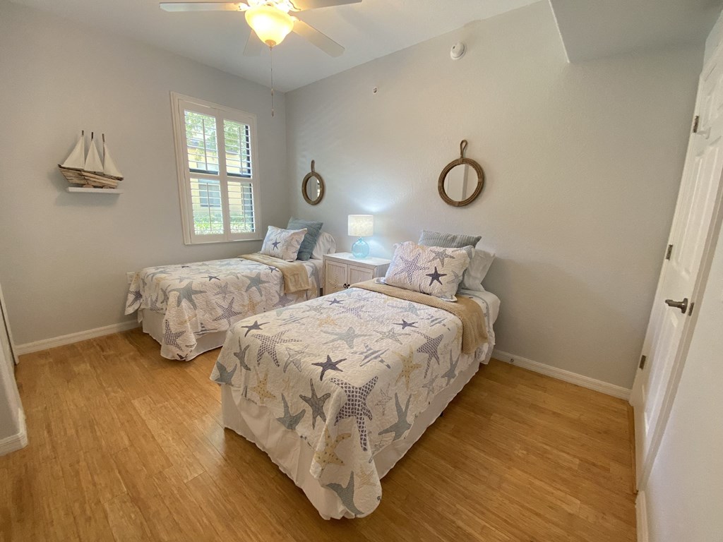 a bedroom with two beds and a ceiling fan