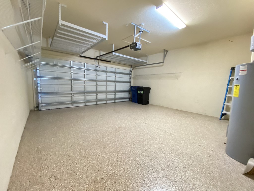 a large room with a garage door and a ceiling fan