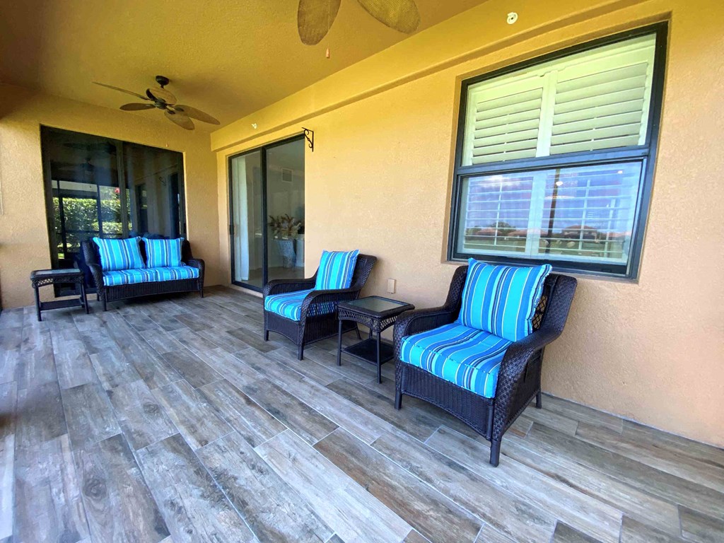 a covered porch with chairs and a sliding glass door