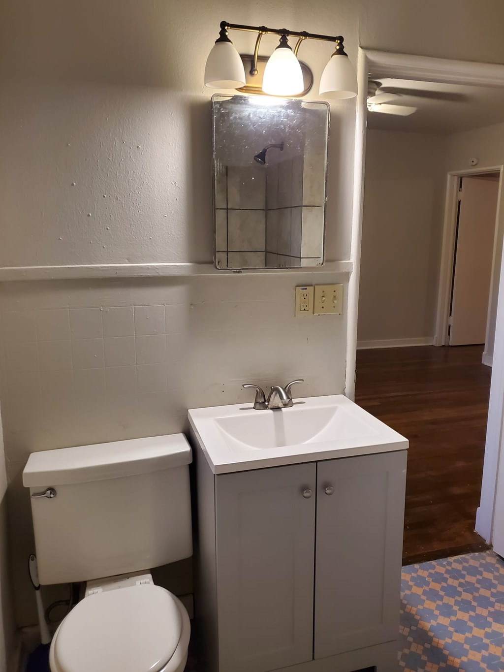 A white toilet and sink in a small bathroom.