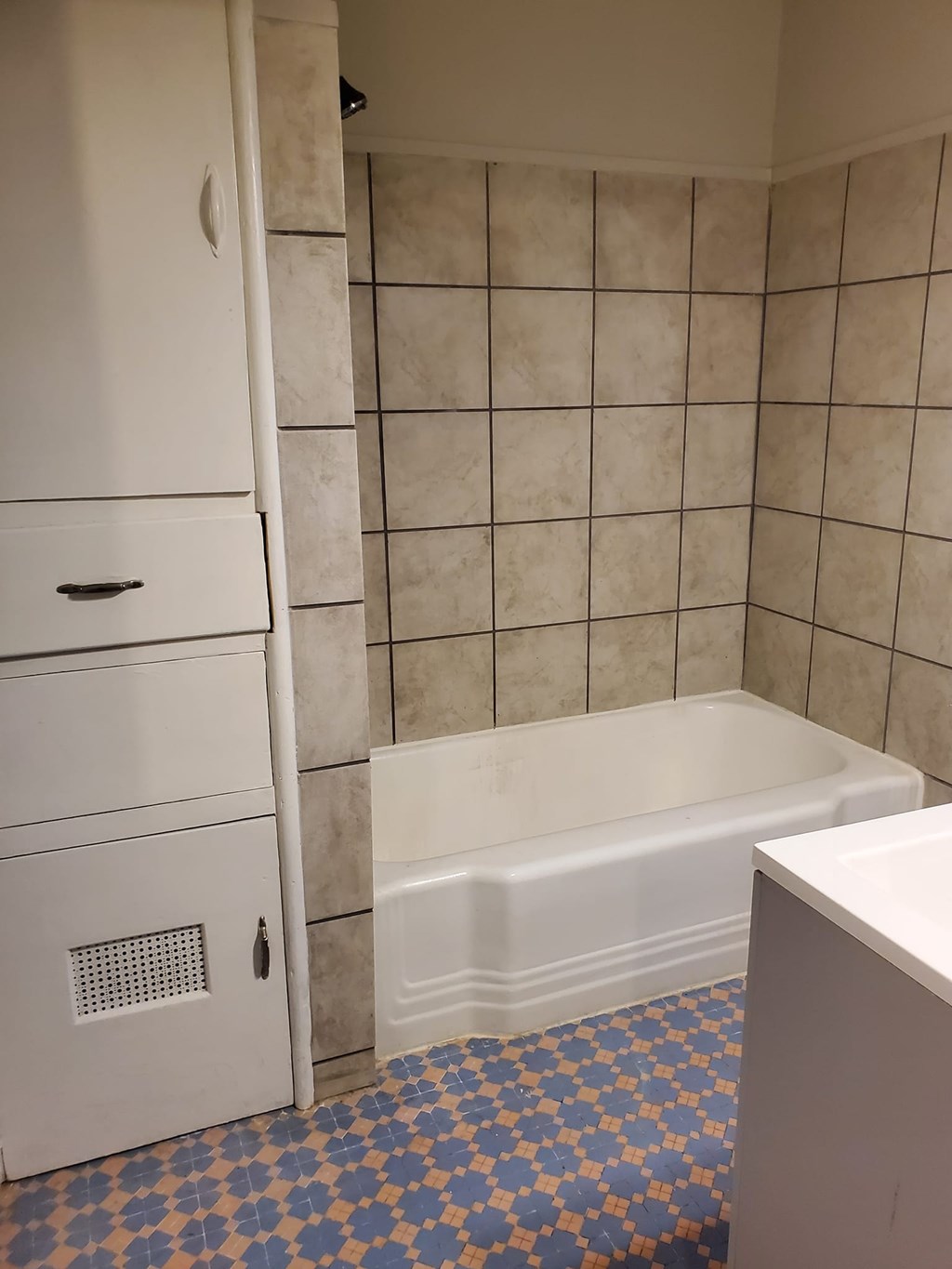 A white bathroom with a tiled shower and a white bathtub.