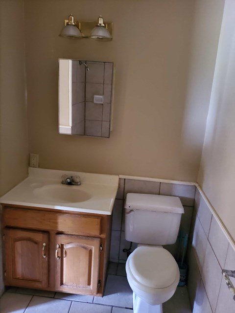 A white toilet sits next to a sink in a bathroom.