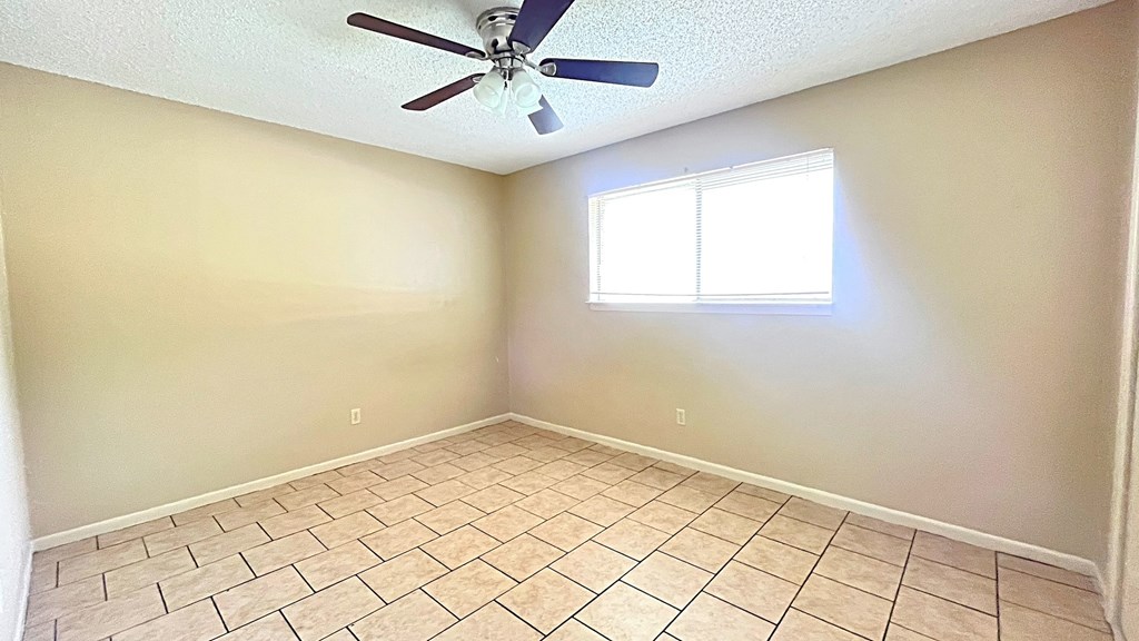 A room with a ceiling fan and a window.