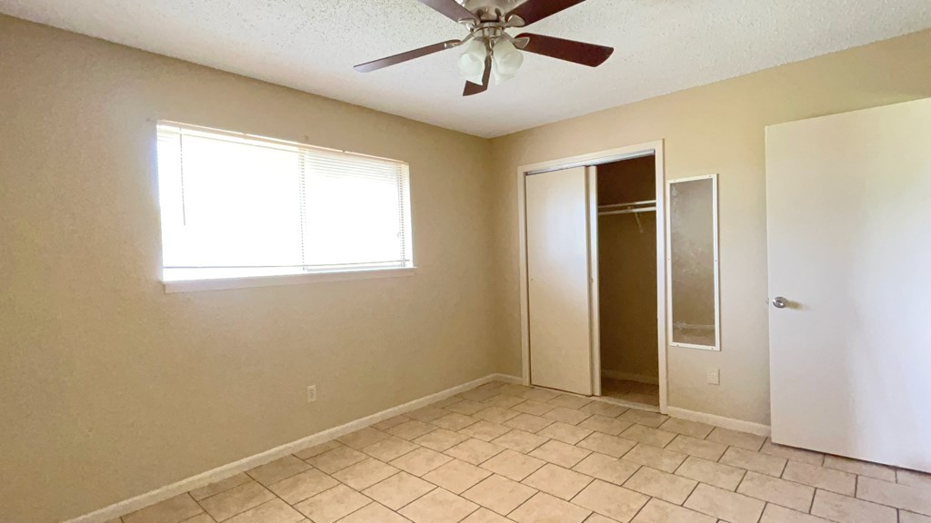 A room with a ceiling fan and a window.