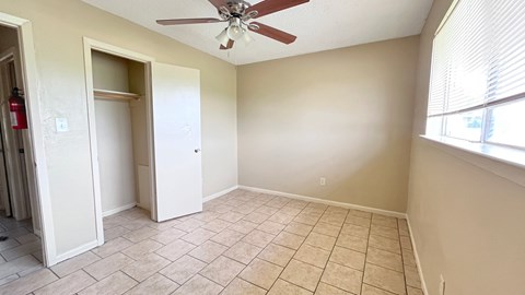A room with a ceiling fan and tile flooring.