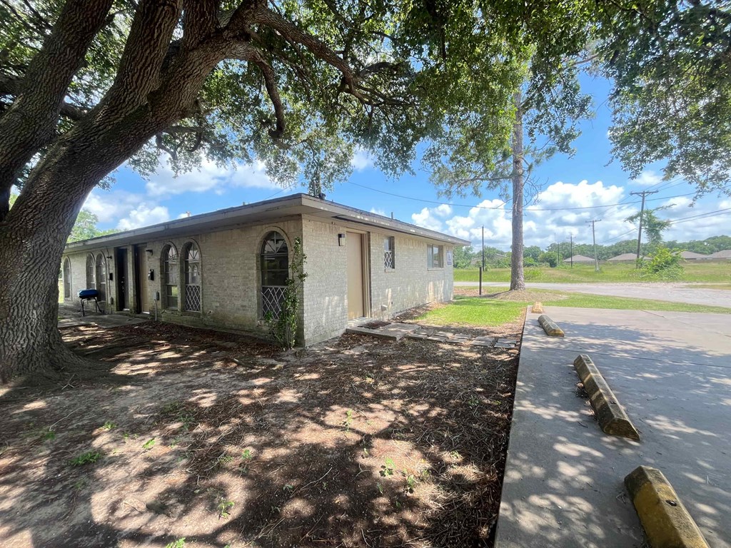 A small building with a tree in front of it.