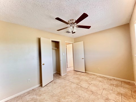 a living room with a ceiling fan and a closet