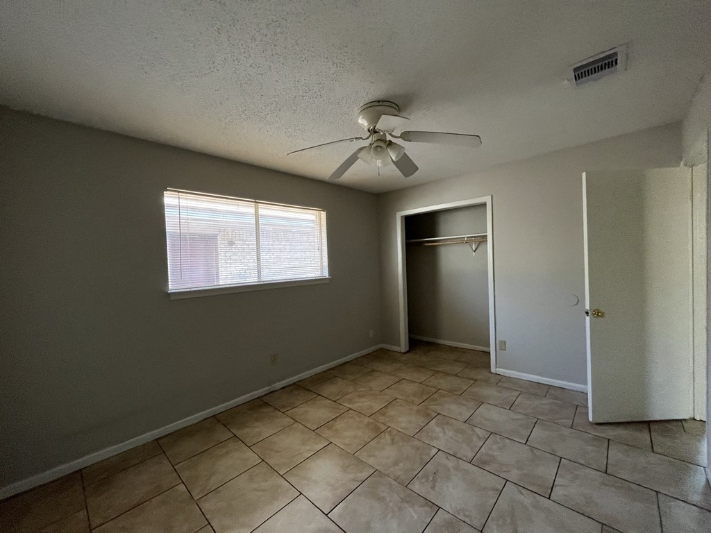 the living room of an empty house with a ceiling fan