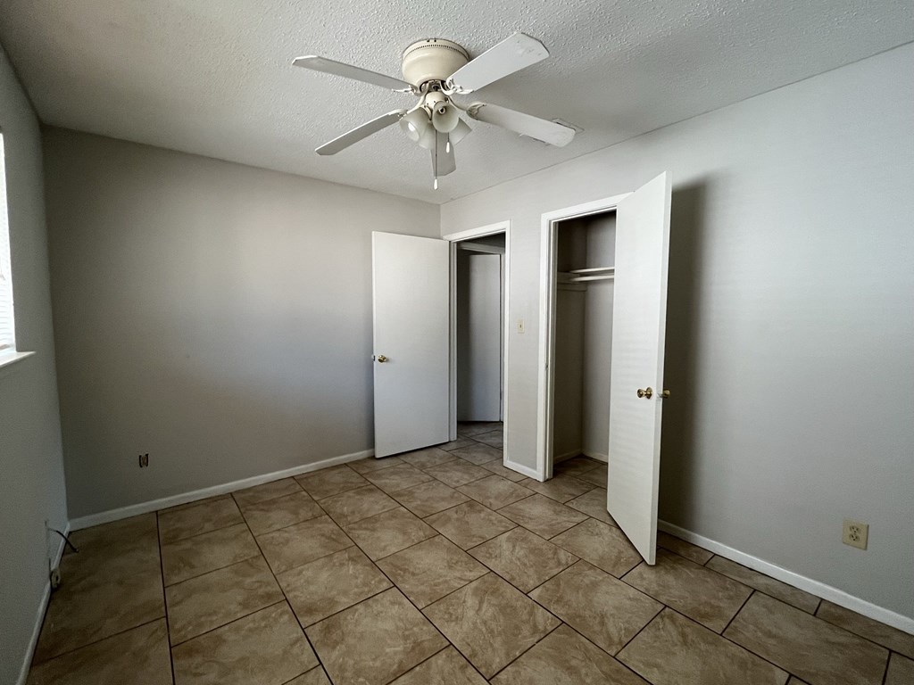 the living room of an empty house with a ceiling fan
