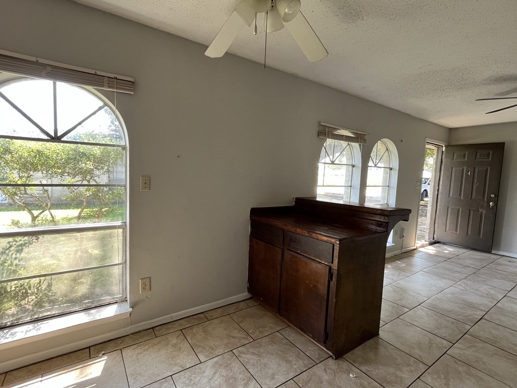 an empty living room with a dresser and a window